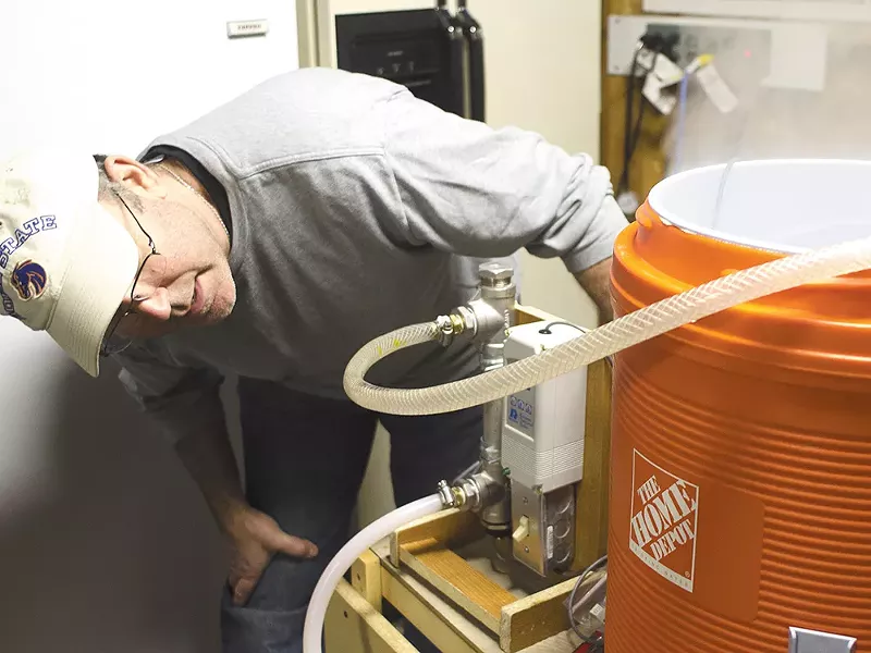 Brian Kennedy inspects his homebrewing system. - JACOB JONES
