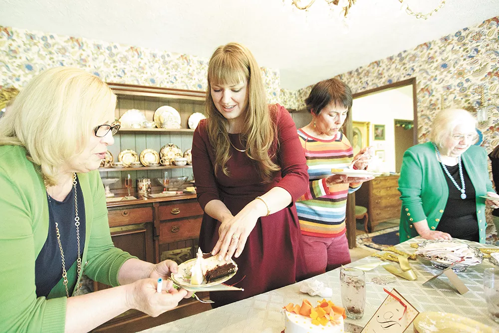 Bride-to-be Charlotte Boutz, center, serves Happy Cake Co.'s Tuxedo Cake with raspberry filling to Karen Fitzpatrick during a bridal shower. - YOUNG KWAK