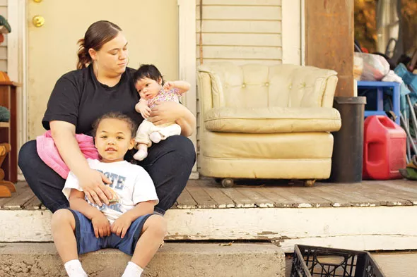 Carol’s daughter, Carrie Collette, sits with her son, Dion, and daughter Eillie in front of their east Spokane home. It will be bulldozed next year to make way for the North-South Freeway, and Collette fears she won’t find a safe place for her family because of her own felony record. - YOUNG KWAK
