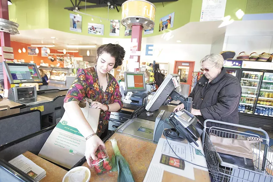 Cashier Syd Silva bags groceries for Halina Slobodow at Main Market Co-op. - YOUNG KWAK