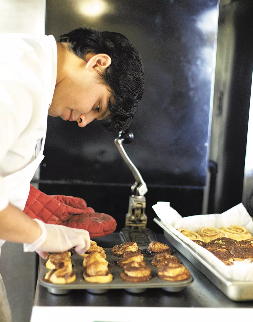 Clay Cerna, general manager of Sweetbox Delivery, works on his cinnamon rolls at Kitchen Spokane. - YOUNG KWAK