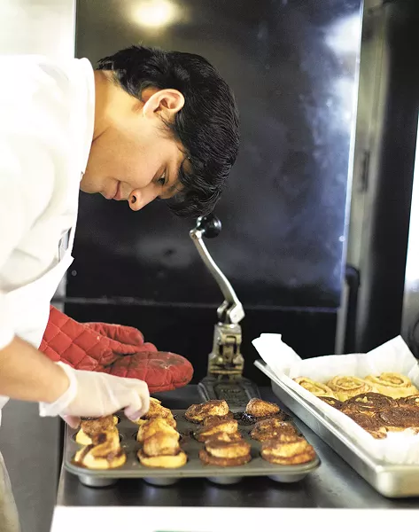 Clay Cerna, general manager of Sweetbox Delivery, works on his cinnamon rolls at Kitchen Spokane. - YOUNG KWAK