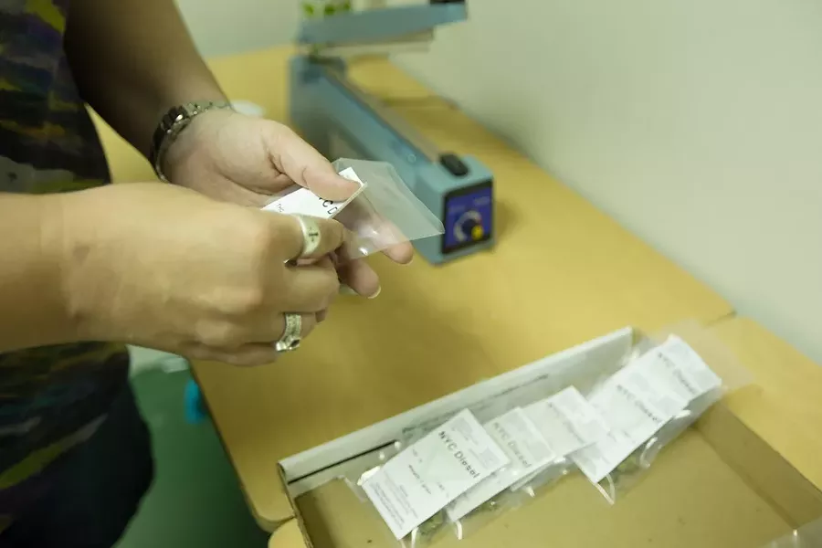Co-Owner Johanna Tuttle places a label onto a one gram bag of New York City Diesel marijuana. - YOUNG KWAK