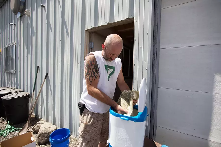 Co-Owner Wesley Tuttle squeezes a bag filled with marijuana leaves and stems while making hash. - YOUNG KWAK