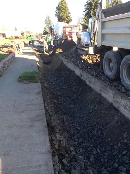 Crews work to install the three adjacent storm gardens along West Garland in the Shadle neighborhood. - THE LANDS COUNCIL