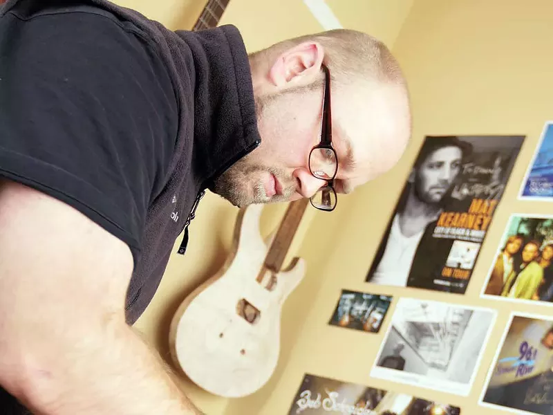 Danny Songhurst carving the neck of a guitar. - YOUNG KWAK