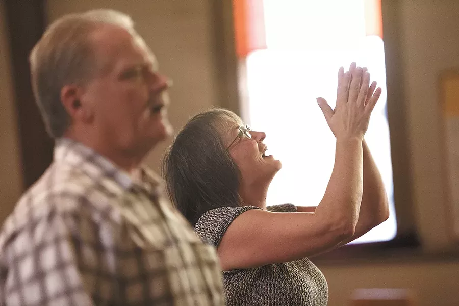 Darla Marlow, right, worships during services at First Covenant Church. - YOUNG KWAK