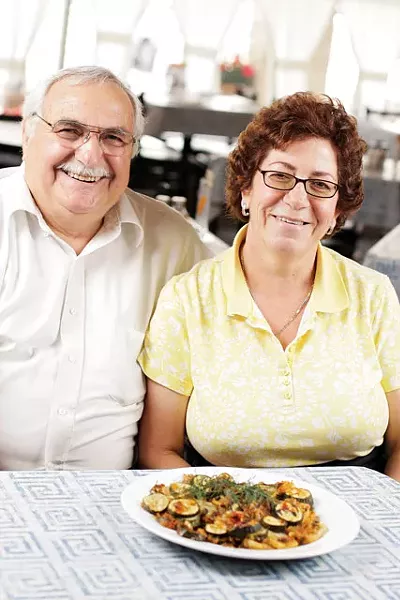 Dino and Fotini Tsakarestos with their zucchini-and-potato casserole at Santorinis Greek Cuisine in Coeur d'Alene. - YOUNG KWAK