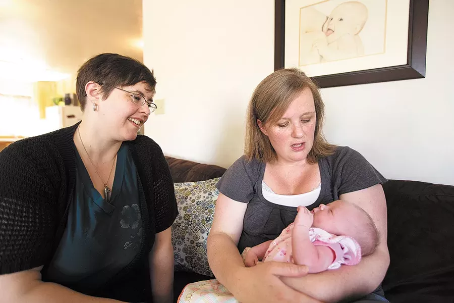Doula Xylina Weaver (left) admires Tiffany Long's 12-day-old daughter Olivia at Spokane Midwives. - YOUNG KWAK