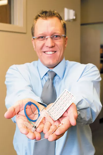 Dr. Jason Reuter displays various contraceptives available at Spokane OBGYN. - STEPHEN SCHLANGE