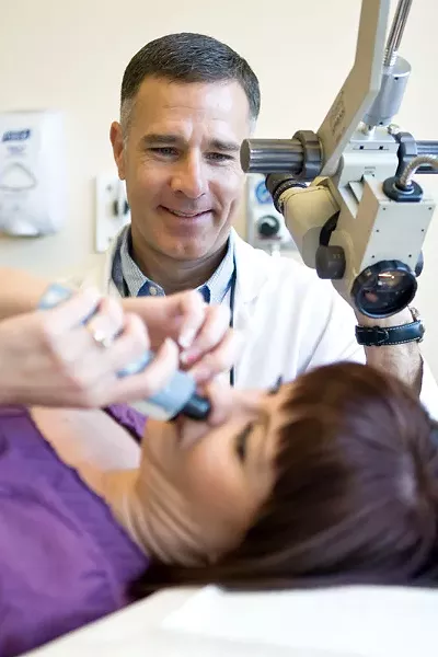 Dr. Michael Olds helps Stephanie Bennett learn to use the EarPopper. - STEPHEN SCHLANGE