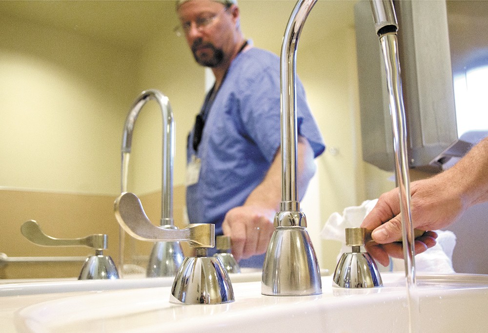 Ed Harrich, director of Surgical Services, uses newly installed copper-alloy faucet handles in a maternity room at Pullman Regional Hospital. - JACOB JONES