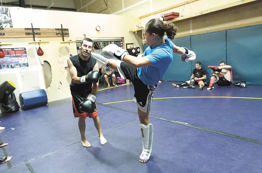 Elizabeth Phillips, right, kicks while sparring with Ron Nance at Sik-Jitsu. - YOUNG KWAK