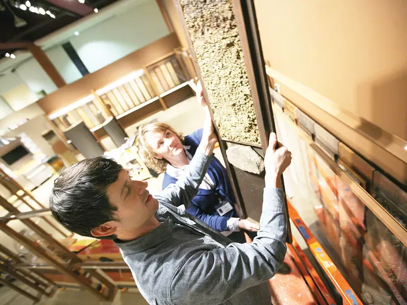 Exhibit designer Ryan Hardesty, left, and soil scientist Chandra Neils install a soil monolith for the exhibit Dig It! - YOUNG KWAK