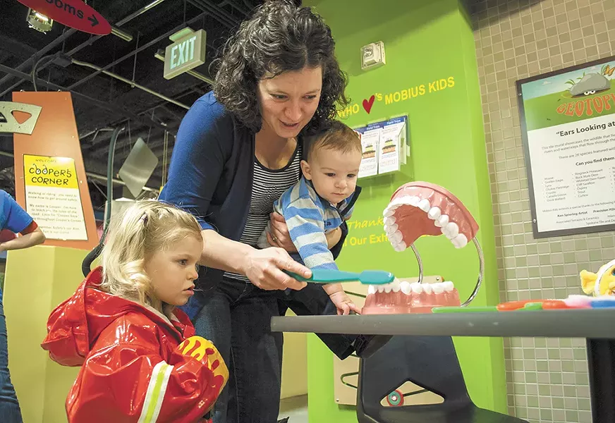 Jami Cary and her kids Rose and Justin work on toothbrushing at Mobius. - SARAH WURTZ