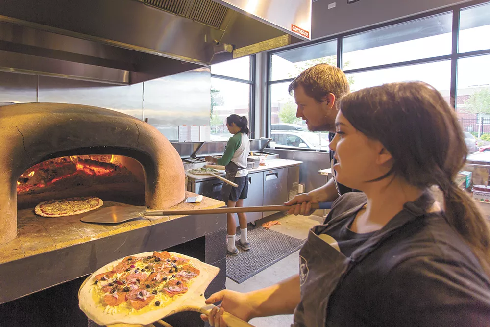 Konstantin Kushner and Jillian McCann cooking with the new restaurant’s wood-fire oven. - MATT WEIGAND