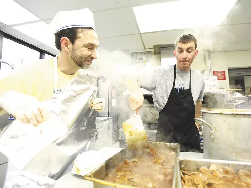 Lloyd Halpern, left, watches Jordan Bressler pour sauce onto brisket. - YOUNG KWAK