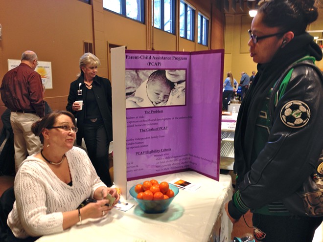 Lockett speaks with Yvonne Levno at the table for the Parent-Child Assistance Program, which helps mothers build and maintain healthy family lives and works to prevent alcohol and drug exposure of children before birth. - CLARKE HUMPHREY