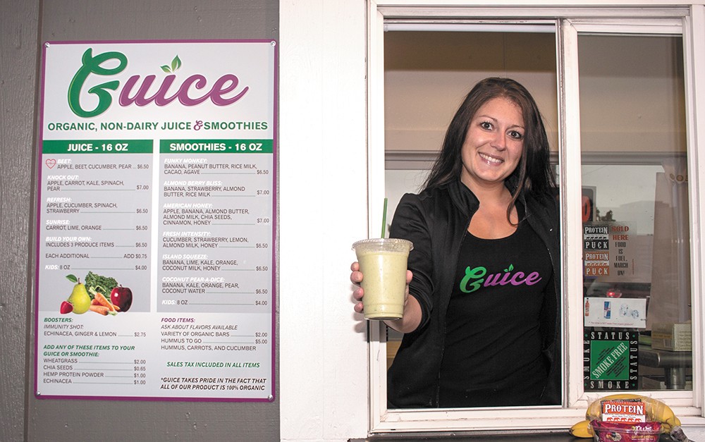 Michelle Kinyon serves an organic juice from Guice's drive-through. - ASHLEY TOMLINSON