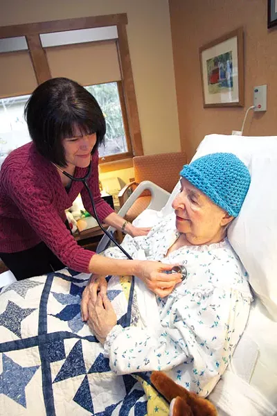 Nurse Manager LouAnn Ward checks 83-year-old Kathryn McCullochs chest at Hospice of Spokane. McCulloch has been a client at the hospice for three months. - YOUNG KWAK