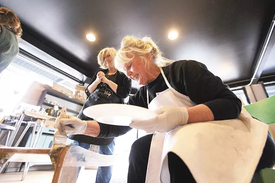 Penny Eaton, right, paints a chair as instructor Annette Tyrrell watches during a class at Artworks Spokane. - YOUNG KWAK