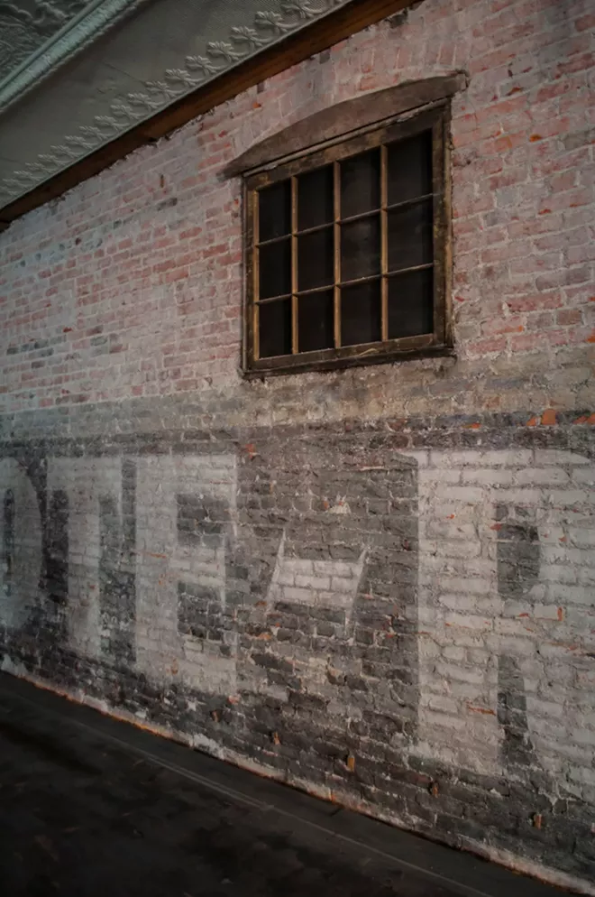 The building once located to the west originally housed a grocery store, and a sign for the business can still be seen on the inside wall of Dania's fourth floor, currently undergoing renovations. - SARAH WURTZ