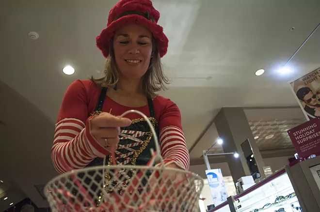 Andrea Worley, otherwise known as Rudi the Elf, hands out candy canes and jingle bells before Santa arrives. - SARAH WURTZ