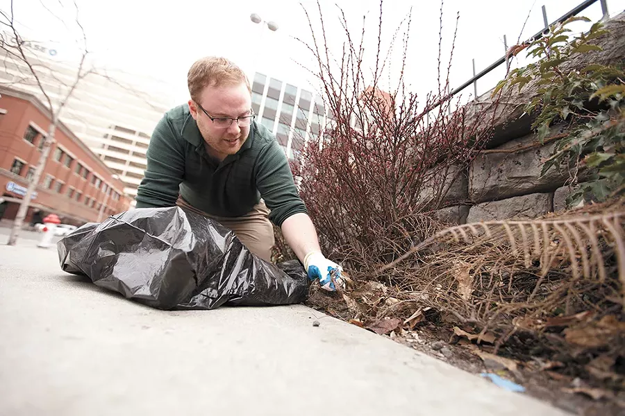 Reed Jessen picks up trash on North Howard Street as a result of a Crowdswell project. - YOUNG KWAK
