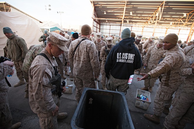 Returning military personnel from combat deployment in Afghanistan throw away unapproved items for travel. - YOUNG KWAK