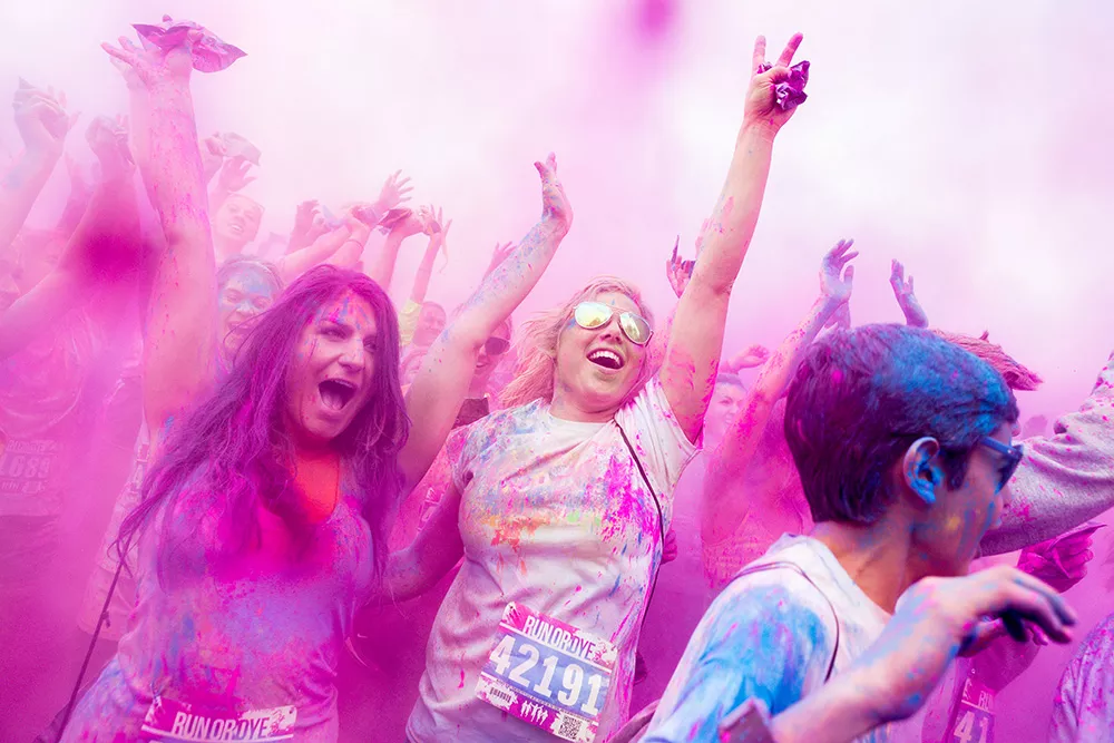 Runners during a dye throw at the post-race party at Run or Dye in Riverside State Park in May. - STEPHEN SCHLANGE