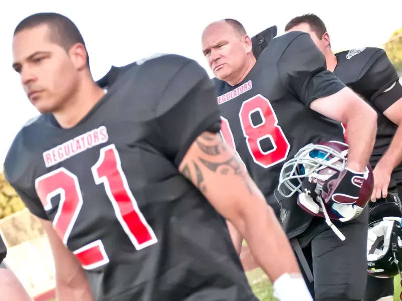 Spokane County Sheriff Ozzie Knezovich (middle) marches onto the football field - AMY HUNTER