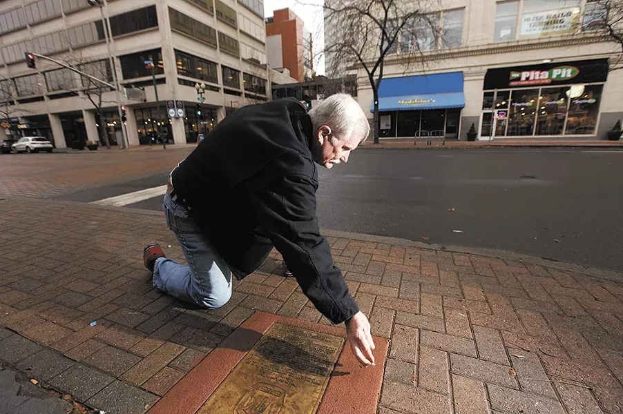 Spokane Fire Department Lt. Greg Borg cleans a memorial for firefighter Leroy A. Mackey, who died Jan. 14, 1966. - YOUNG KWAK