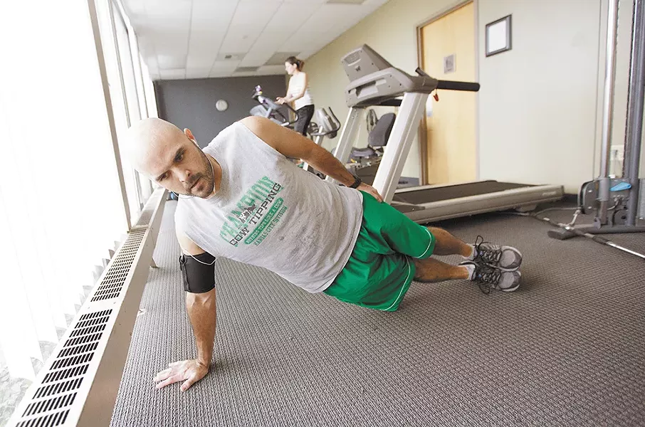 Taking a break from his desk, Inland Imaging Account Manager Travis Thomas works out at the well-equipped office gym. - YOUNG KWAK