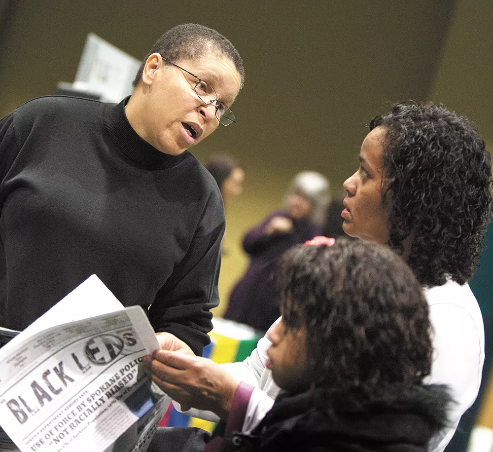 The editor and publisher of the Black Lens, Sandy Williams, left, speaks with Charlotte Lewis and her daughter after the Martin Luther King, Jr. Day rally on Monday. - YOUNG KWAK