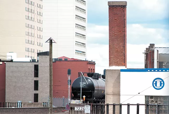 An oil train car passes through downtown Spokane. A consultant hired by the city warned that the city's elevated tracks could lead to a scenario where a train car full of explosive oil derails and lands on top of a building. - DANIEL WALTERS