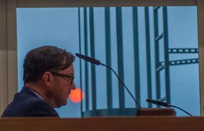 Ben Stuckart, giving a speech on climate change with the blood-orange sun in the background - DANIEL WALTERS PHOTO