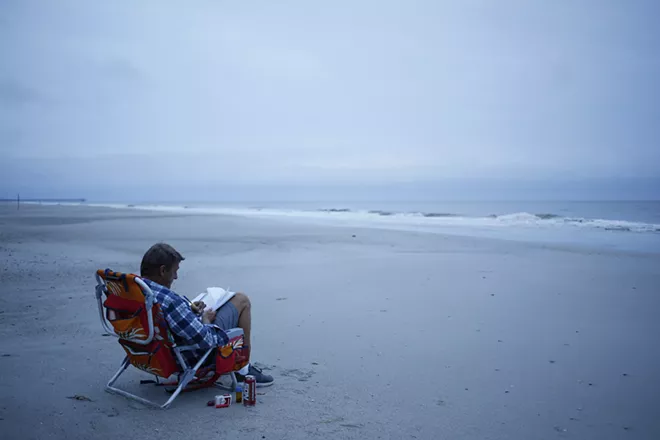 Jerry Bryant spends time on the beach before the arrival of Hurricane Florence in Myrtle Beach, S.C., Sept. 13, 2018. The first rains of Florence were starting to lash North Carolina on Thursday, with the storm growing in size, packing winds of up to 110 miles an hour and driving a storm surge that could reach 13 feet in places. - LUKE SHARRETT/THE NEW YORK TIMES