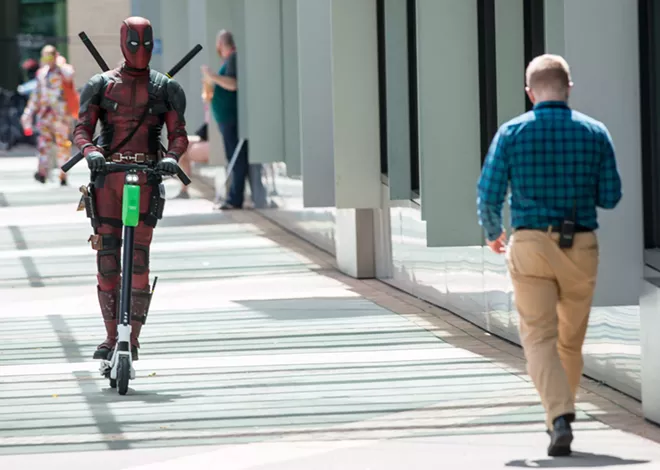 "Deadpool" rides a Lime scooter outside Portland's Rose City Comic Con earlier this fall. - DANIEL WALTERS PHOTO