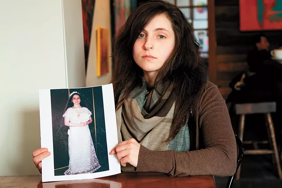 Angel McGehee, née Dwyer, holds a photo from her wedding day, when she was just 13. - JEFF FERGUSON PHOTO