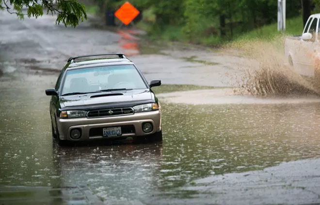 A car sits parked in a massive puddle in flooded Peaceful Valley during last night's rainstorm. - DANIEL WALTERS PHOTO