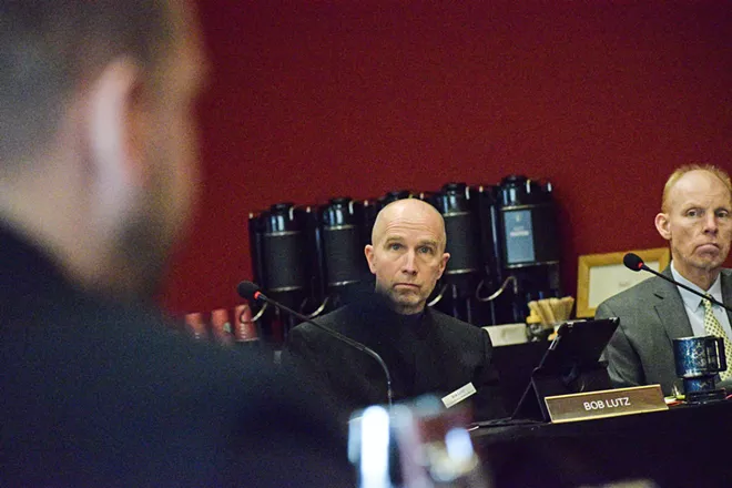 Spokane County Health Officer Bob Lutz listens to the owner of a vaping shop argue against the ban on flavored products.
