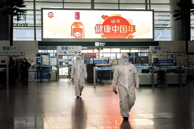 People, wearing protective clothing to guard against the coronavirus, walk in the departure hall of the Beijing South railway station in Beijing on Monday, Feb. 10, 2020. - GIULIA MARCHI/THE NEW YORK TIMES