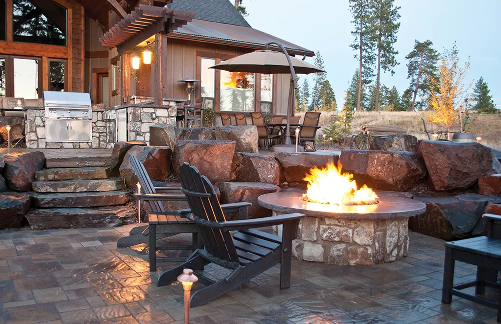 Fire draws people to relax and linger. Legacy Landscapes included a casual yet cozy firepit and a more elaborate outdoor fireplace and covered seating area in these two recent projects. - LEGACY LANDSCAPES