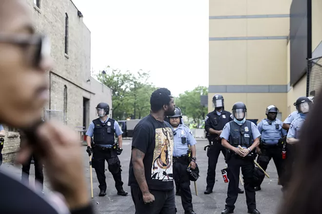 A group of protesters and police outside a police precinct in Minneapolis, Thursday, May 28, 2020. A wave of protests erupted across South Minneapolis overnight and into Thursday, with the police firing tear gas and rubber bullets as people set buildings on fire and looted stores days after George Floyd, an African-American man, died in police custody. - TIM GRUBER/THE NEW YORK TIMES