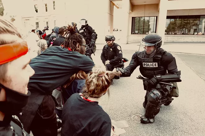 Some local officers kneeled in solidarity with protesters outside the county courthouse. - YOUNG KWAK PHOTO