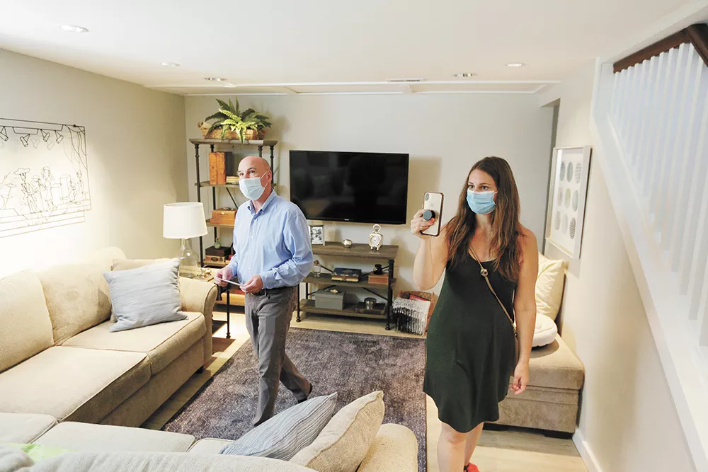 Real estate broker Mike Crowley (left) looks on as Kelsey Martin helps her friends from Seattle look for a property via FaceTime. - YOUNG KWAK PHOTO