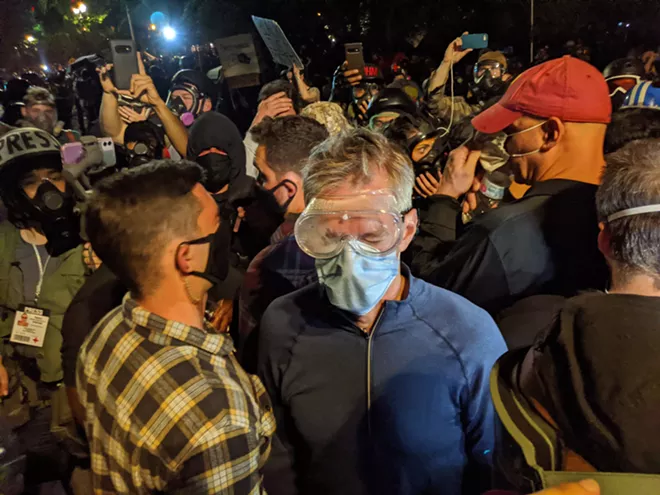 Portland Mayor Ted Wheeler wears goggles and a face mask during a protest against racial inequality and police violence in Portland, Ore. late Wednesday, July 22, 2020. Wheeler, was left coughing and wincing in the middle of his own city Wednesday night after federal officers deployed tear gas into a crowd of protesters that he had joined outside the federal courthouse. - MIKE BAKER/THE NEW YORK TIMES