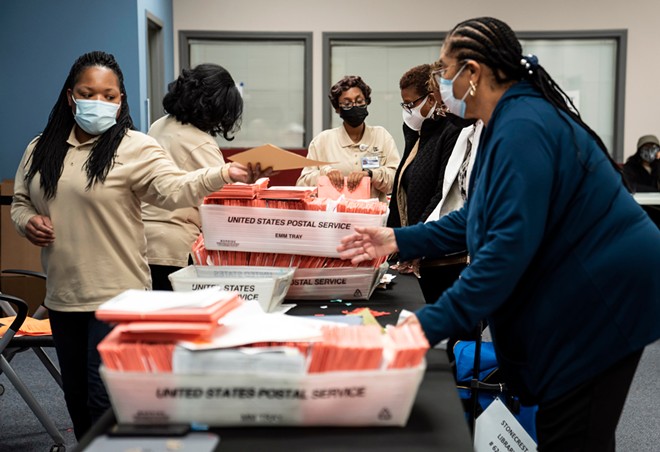 Poll workers sort ballots at the Dekalb County Commissioners office in Decatur, Ga., on Tuesday night, Jan. 5, 2021. Democrats inched closer to taking control of the Senate on Wednesday, winning one of the two Georgia seats up for grabs in a pair of runoff elections while the second contest remained too close to call. - NICOLE CRAINE/THE NEW YORK TIMES