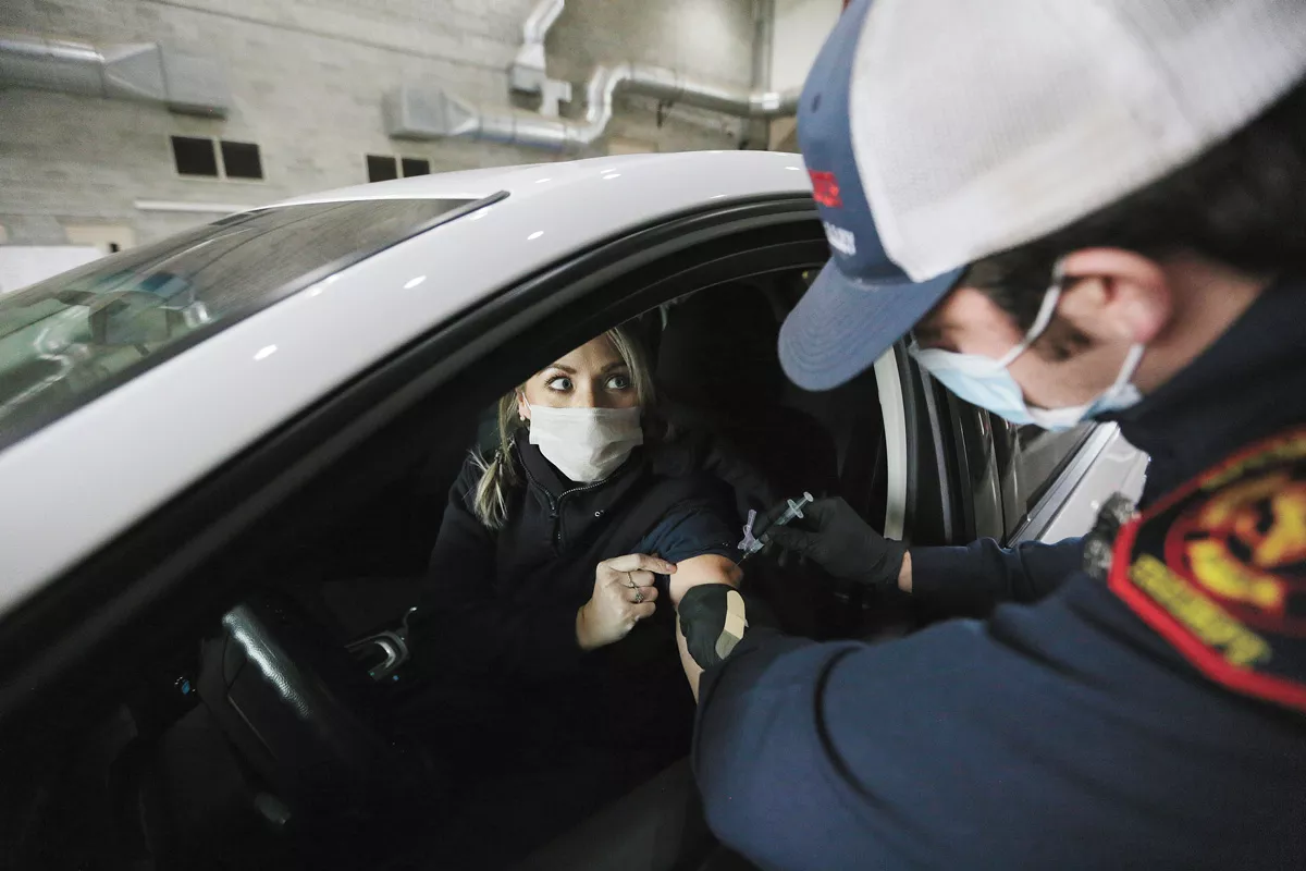 Paramedic Nikko Humphry administers a dose of the Moderna vaccine to dispatcher Sara Thomas at the Spokane Fire Department Training Center. - YOUNG KWAK PHOTO