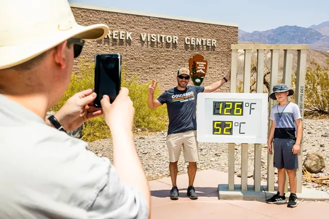 Visitors take photos in front of the thermometer at the visitors center in Furnace Creek at Death Valley National Park in Death Valley, Calif., on July 10, 2021. Much of the West again faces record-breaking temperatures over the coming days, with over 31 million people in areas under either an excessive heat warning or a heat advisory. It is the third heat wave to sweep the region this summer. - ROGER KISBY/THE NEW YORK TIMES